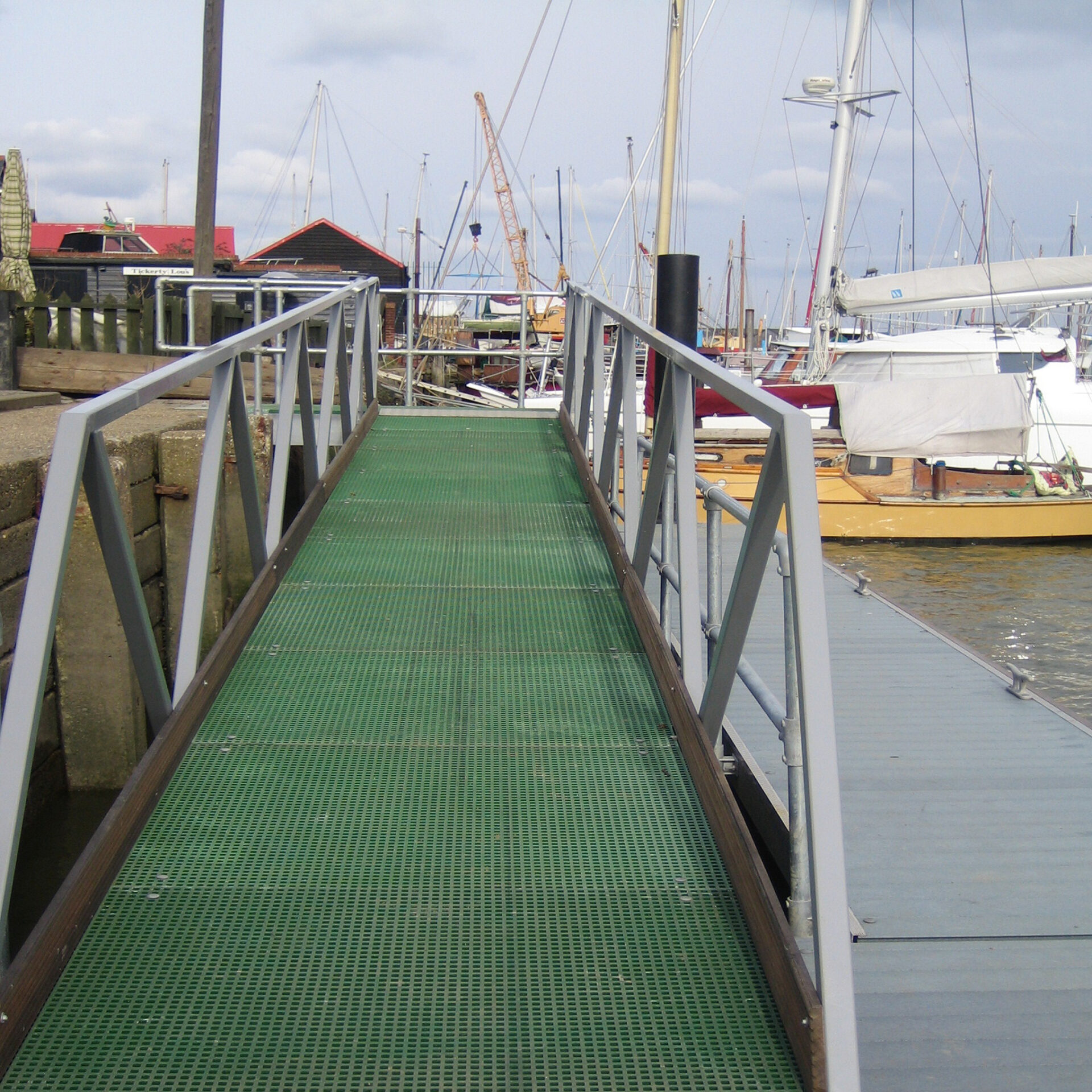 Green QuartzGrip GRP MIni Mesh Grating used to resurface a ramp going from the shore to a floating pontoon