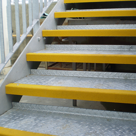 Yellow anti-slip GRP stair nosing installed on metal checker plate steps