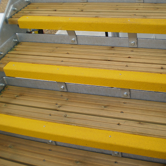 Yellow anti-slip GRP stair nosing installed on wooded steps