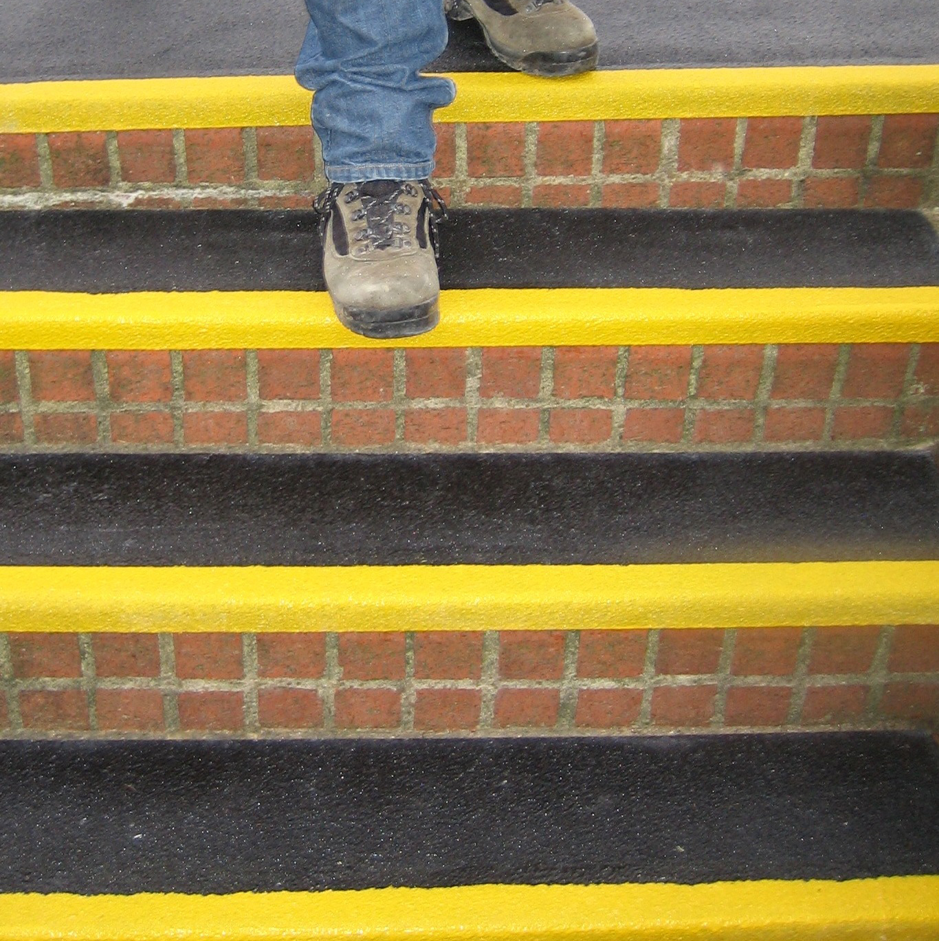 Black and yellow QuartzGrip anti-slip Stair Tread Covers installed on bicks steps