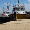 Photo taken on a sunny day showing the RNLI pontoon at Mistley Marina resurfaced using beige QuartzGrip GRP min i mesh marina decking