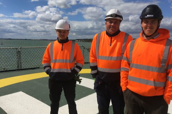 Three members of one of Step on Safetys installation teams on the deck of a Trinity House vessel