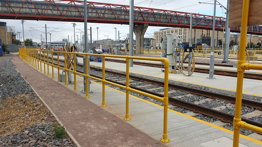 An extended stretch of SafeClamp GRP handrail running alongside railway lines at Cambridge depot