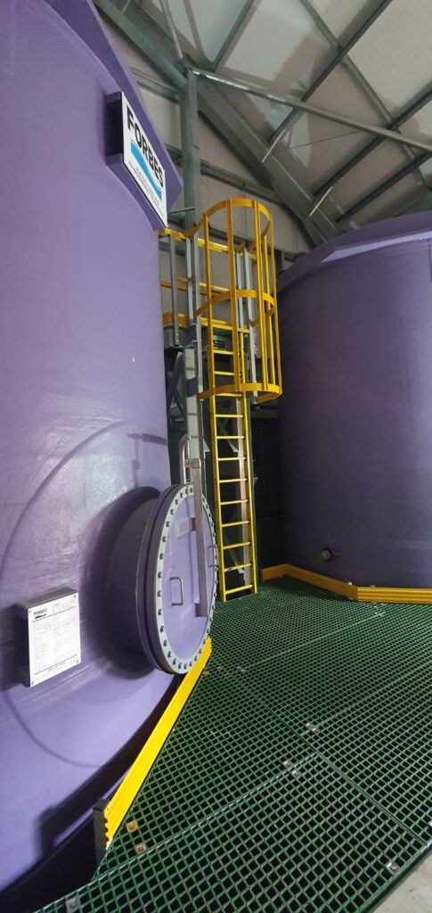 Access platform and bund floor at whitehillocks water treatment works. Steps and floor are made using QuartzGrip GRP standard open mesh panels in green. Hellow stair nosing, handrails and kickplate highlight the hazardous areas