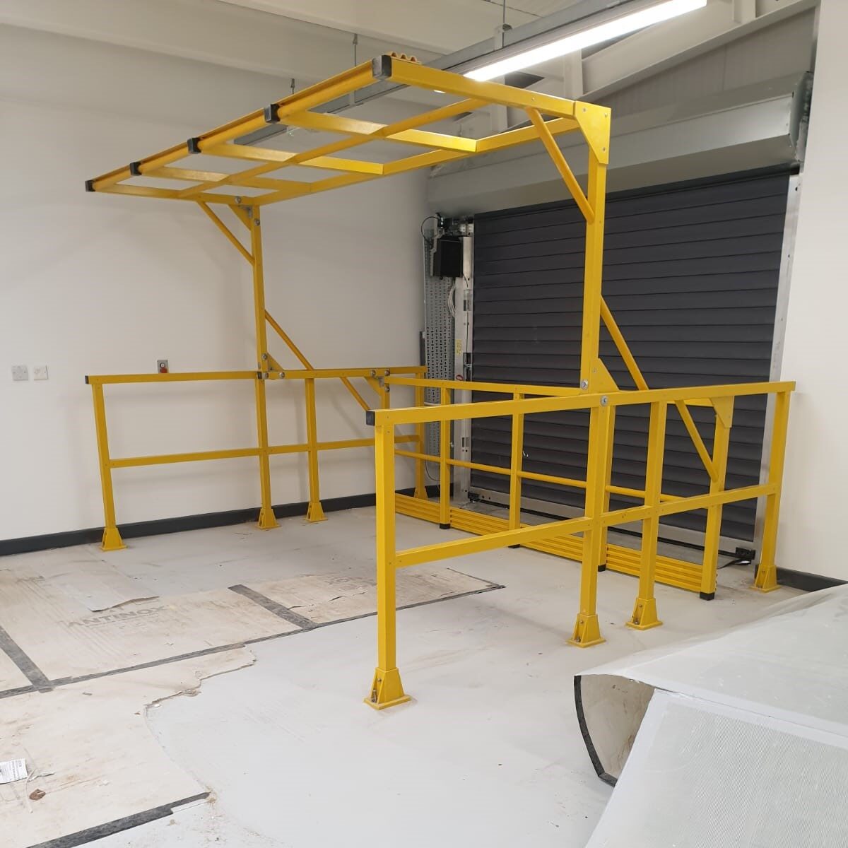 Yellow GRP Pallet Gate in front of closed shutter doors