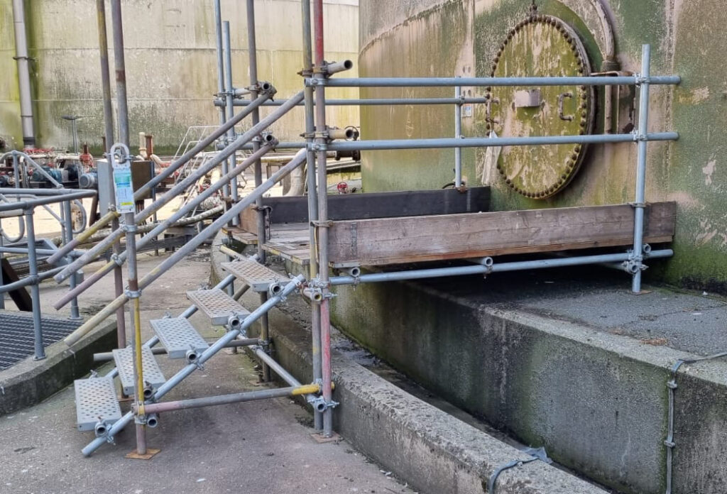 A temporary structure made from scaffolding providing access to a silo hatch